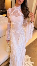 Vestido de noche formal para mujer Sansa personalizado en color blanco marfil, con cuello alto, mangas acampanadas de encaje transparente, flecos escalonados y encaje, estilo sirena, largo maxi.